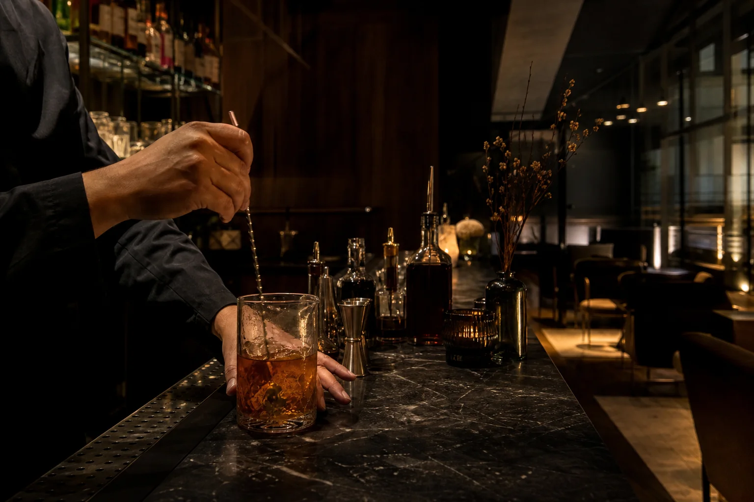 Barmen precizno priprema koktel za šankom